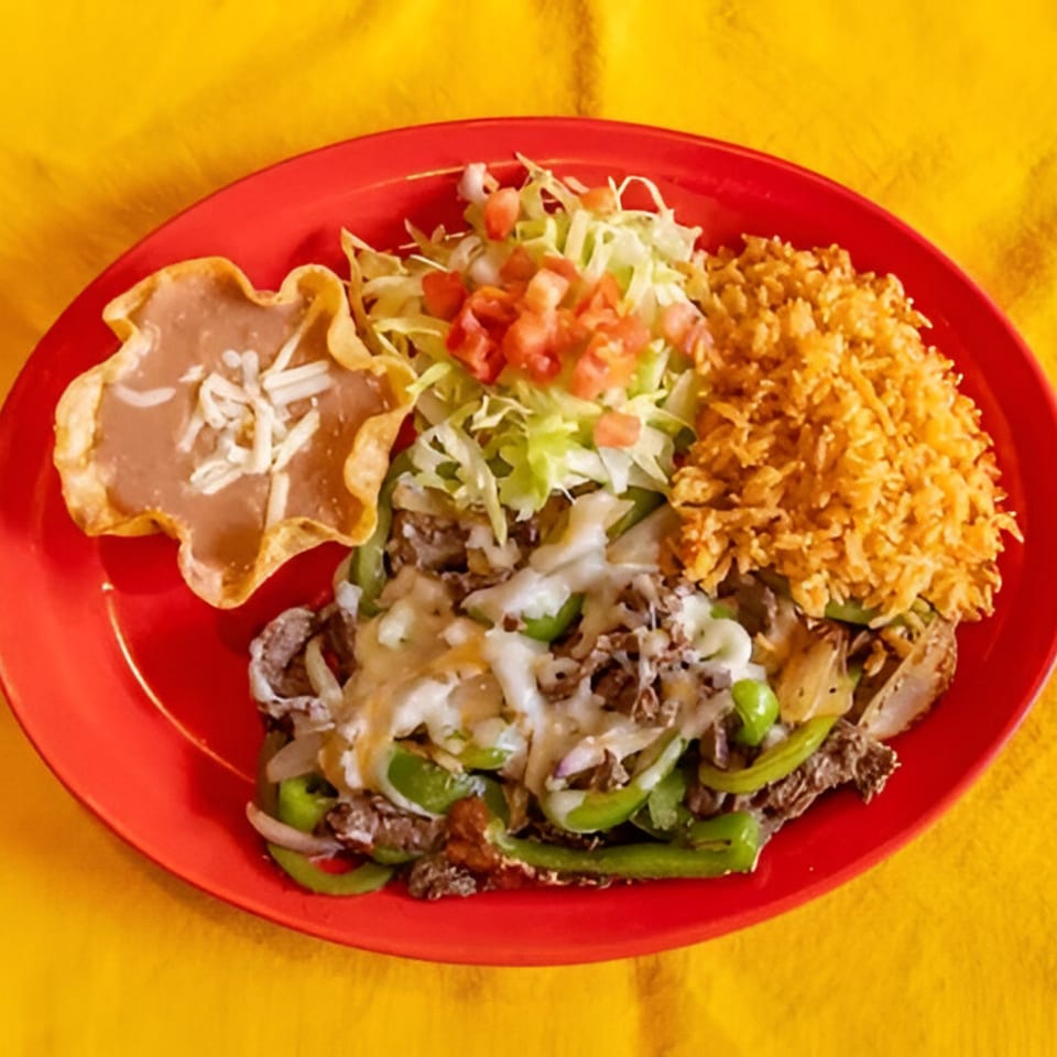 Taxco Mexican Cuisine's steak fajita with rice, beans, and salad on a red plate.