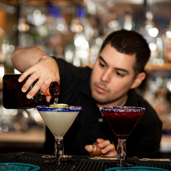 A bartender pouring a drink into a margarita glass at Taxco Mexican Cuisine.
